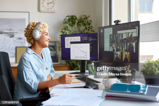 happy businesswoman on video call with colleagues - sguardo e complicità foto e immagini stock
