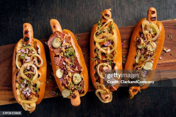 artisan hot dogs in brioche rolls with pickles, onion and relishes. - hot dog stock pictures, royalty-free photos & images