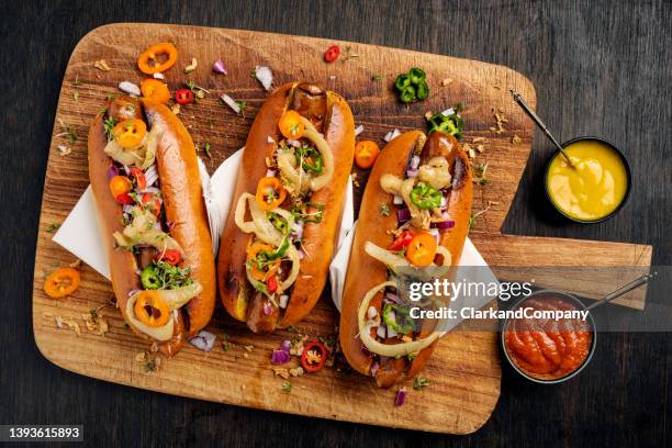 artisan hot dogs in brioche rolls with pickles, onion and relishes. - artisanal food and drink stock pictures, royalty-free photos & images