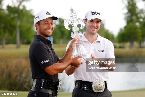 Xander Schauffele and Patrick Cantlay pose with the trophy after putting in to win on the 18th green during the final round of the Zurich Classic of...