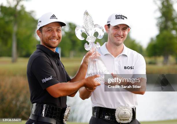 Xander Schauffele and Patrick Cantlay pose with the trophy after putting in to win on the 18th green during the final round of the Zurich Classic of...