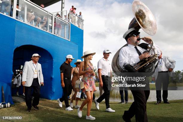 Patrick Cantlay and his partner Nikki Guidish, along with Xander Schauffele and his wife Maya, walk up to the 18th green for the trophy ceremony...