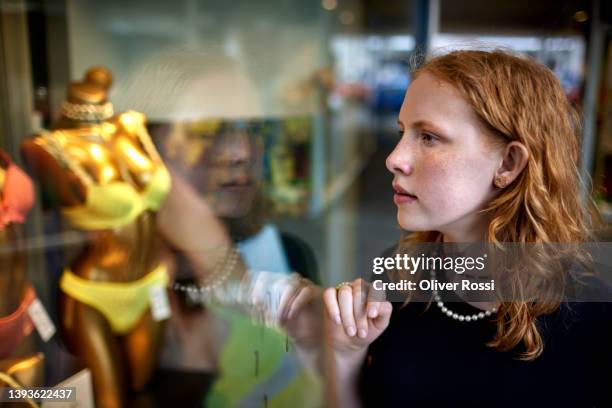 teenage girl looking into shop window - girl after shopping stock-fotos und bilder