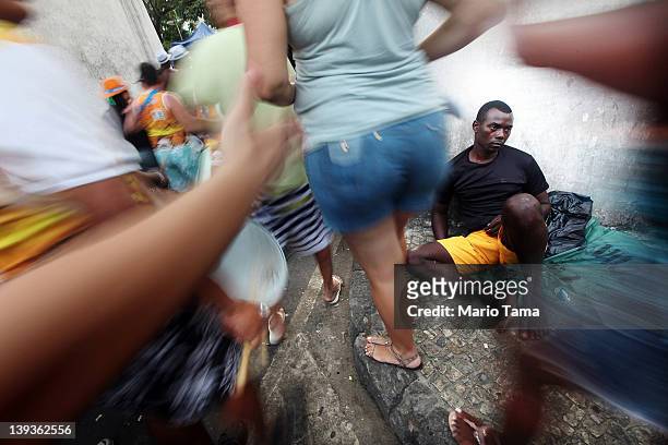 Man rests as Brazilian revelers parade during Carnival celebrations on February 19, 2012 in Rio de Janeiro, Brazil. Carnival is the grandest holiday...