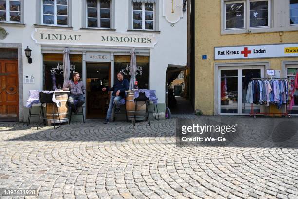 restaurant and café "lindau memories" and the red cross shop in fischergasse in lindau on lake constance - lakeside shopping centre stock pictures, royalty-free photos & images