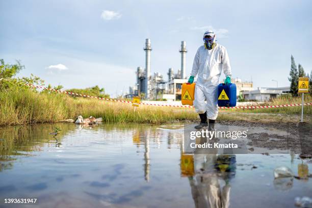 scientists in radiation protection suit working with dangerous materials at industrial site background. - radiation symbol stock pictures, royalty-free photos & images