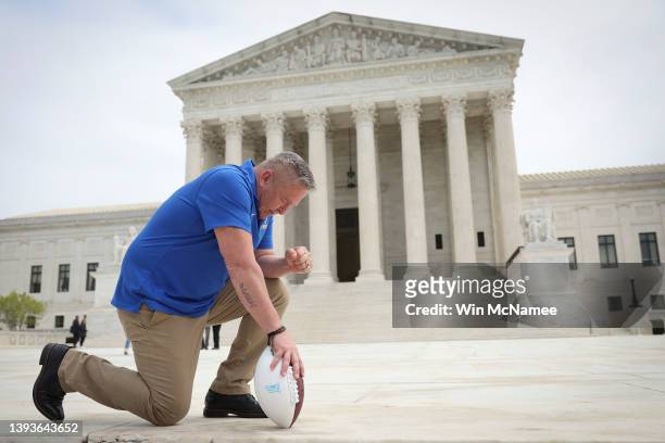 Former Bremerton High School assistant football coach Joe Kennedy takes a knee in front of the U.S. Supreme Court after his legal case, Kennedy vs....