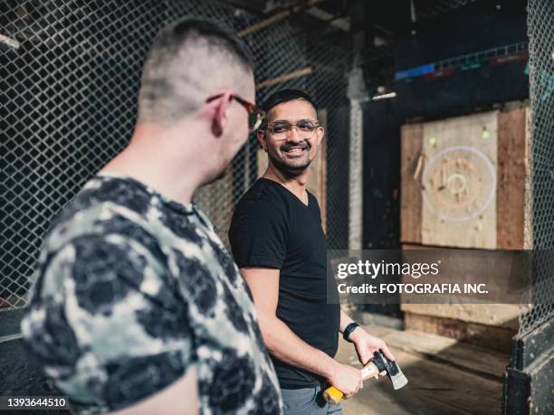 young gay men at the axe throwing game room - axe throwing stock pictures, royalty-free photos & images