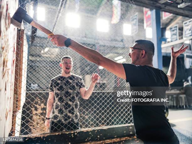 young gay men at the axe throwing game room - machado imagens e fotografias de stock