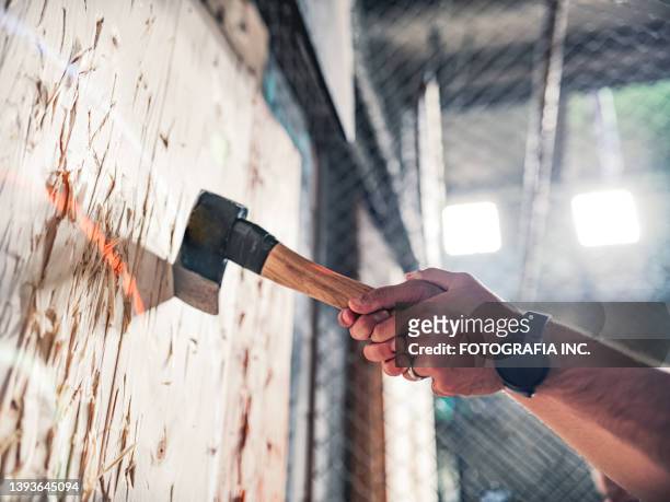 young gay man throwing axe at the game range - throwing stock pictures, royalty-free photos & images