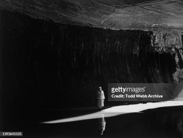 Portrait of American artist Georgia O'Keeffe as she stands beside a shaft a light in Twilight Canyon, New Mexico, 1964.