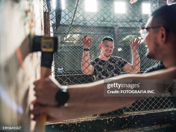 young gay men at the axe throwing game room - axe throwing stock pictures, royalty-free photos & images