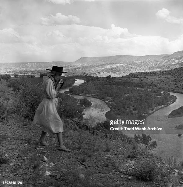 View of American artist Georgia O'Keeffe as she photographs the Chama River from an overlook, New Mexico, 1951.