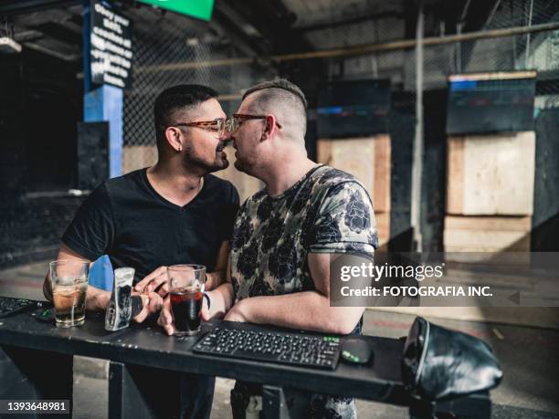 young gay men at the axe throwing game room - axe throwing stock pictures, royalty-free photos & images