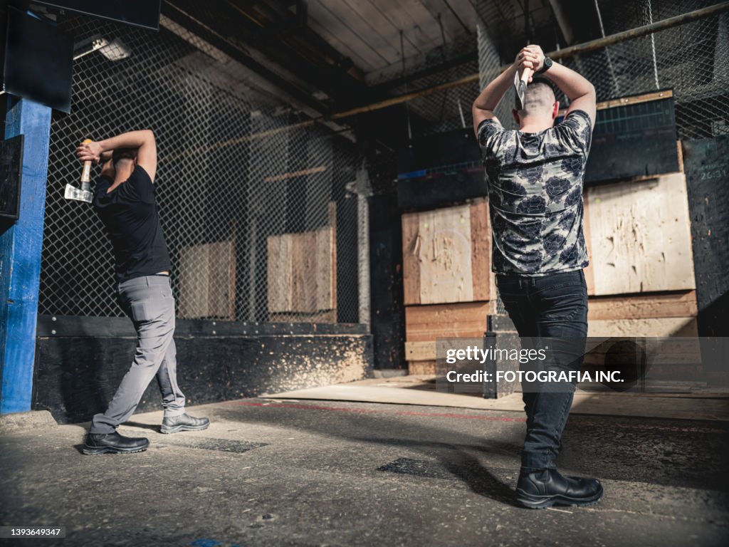 Young gay men at the axe throwing game room