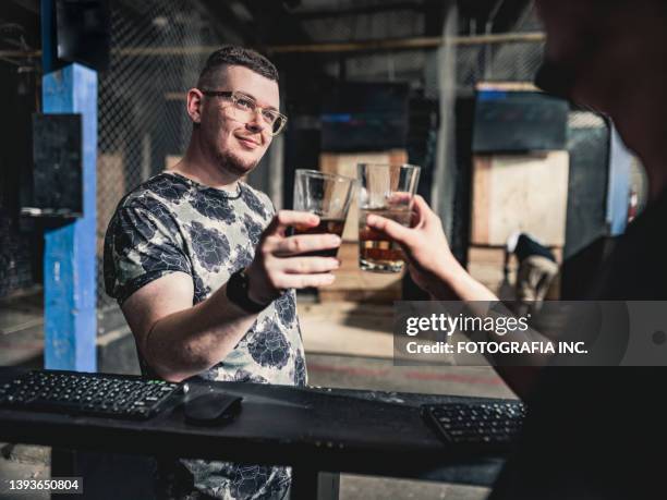 young gay men at the axe throwing game room - axe throwing stock pictures, royalty-free photos & images