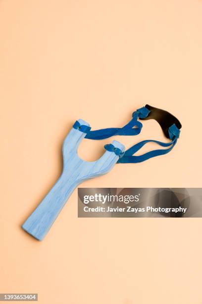 wooden slingshot on pastel background - rubber imagens e fotografias de stock