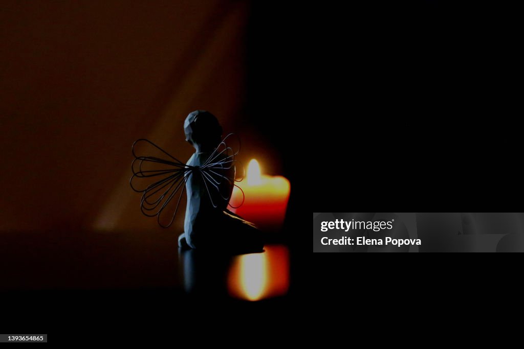 Angel Wings Silhouette Against Wax Burning Candle