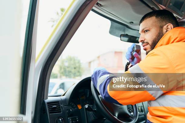 portrait of emergency worker using talk radio and driving in - operatore di prima linea foto e immagini stock