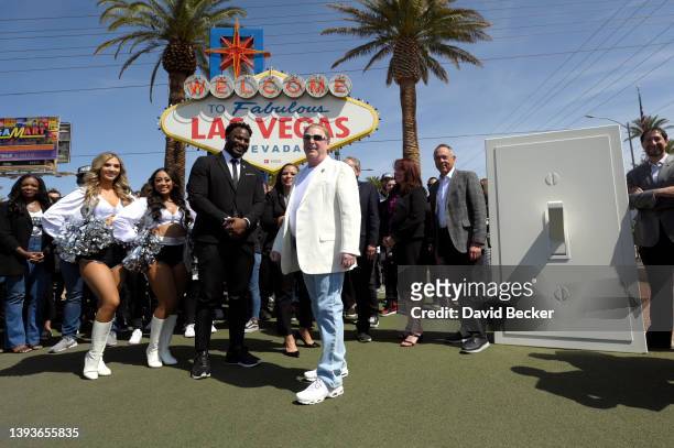 Former Las Vegas Raiders player Marcel Reese and Las Vegas Raiders owner Mark Davis stand together after Davis flipped an oversized ceremonial light...