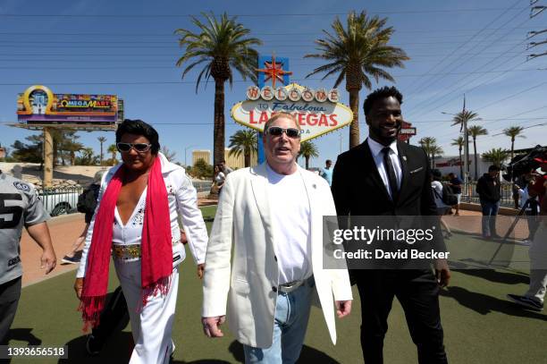 An Elvis Presley impersonator walks by Las Vegas Raiders owner Mark Davis and former Las Vegas Raiders player Marcel Reese during a kick-off event...