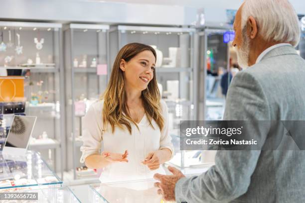 senior man buying jewelry - juwelier stockfoto's en -beelden