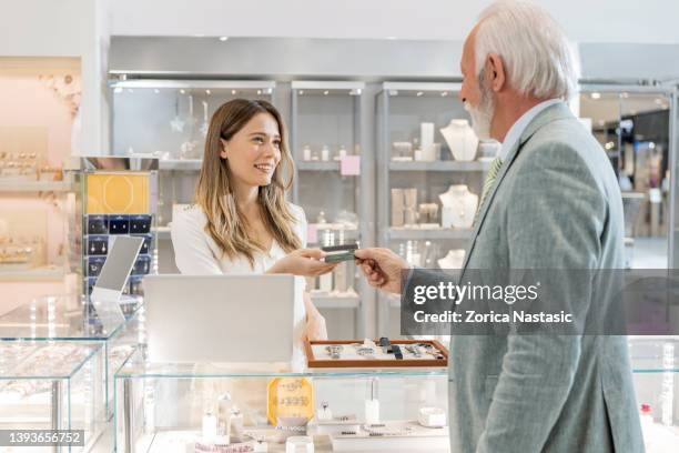 paying with credit card in jewelry store - juwelier stockfoto's en -beelden
