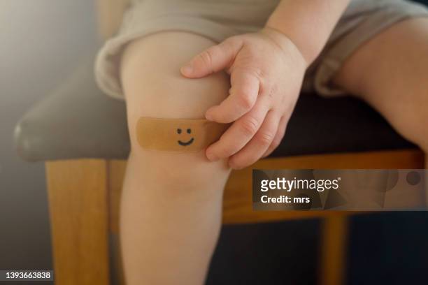 child with a plaster on knee - applying plaster stock pictures, royalty-free photos & images