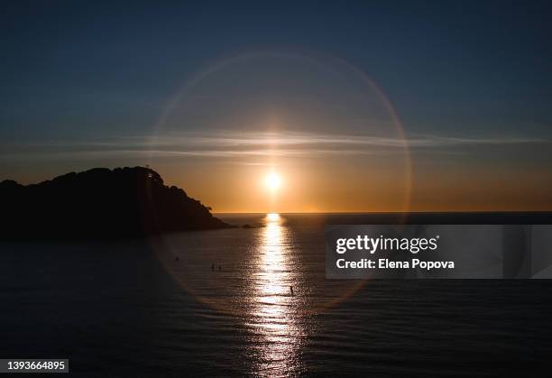 solar halo above mediterranean sea on sunset moment - buddhism photos et images de collection