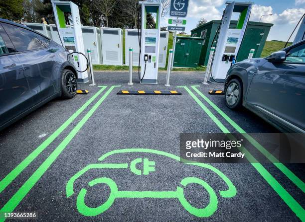 Electric cars at a motorway service station are charged by a bank of electrical chargers on April 24, 2022 in Exeter, England. The government's...