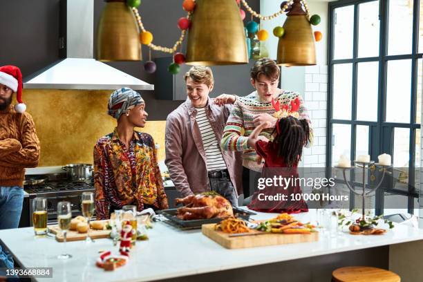 family enjoying christmas dinner preparations in kitchen - party social event stock pictures, royalty-free photos & images