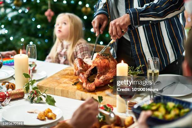 man carving christmas turkey on table - cooked turkey white plate stockfoto's en -beelden