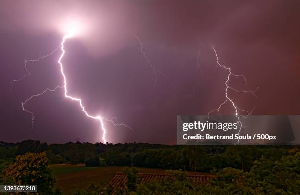 lightnings in a summer evening,panoramic view of lightning over field against sky at night,chanas,france - orage photos et images de collection