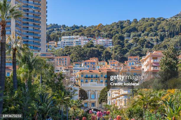 monte carlo residential buildings in bright sunlight surrounded by green trees - monaco nice stock-fotos und bilder