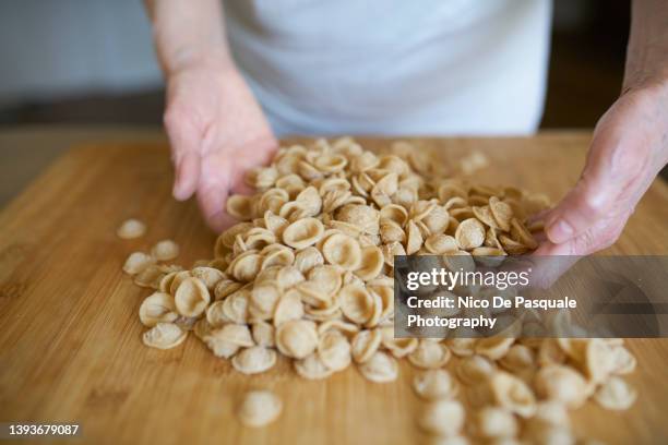senior woman holding handmade pasta - orecchiette pasta stock pictures, royalty-free photos & images