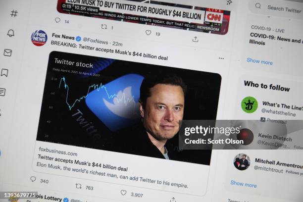 In this photo illustration, news about Elon Musk's bid to takeover Twitter is tweeted on April 25, 2022 in Chicago, Illinois. It was announced today...