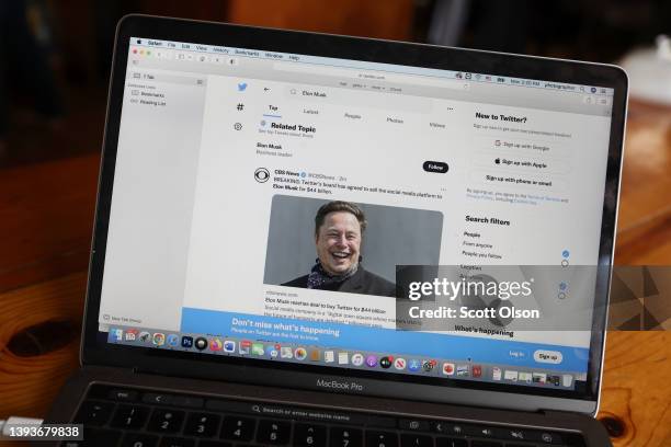 In this photo illustration, news about Elon Musk's bid to takeover Twitter is tweeted on April 25, 2022 in Chicago, Illinois. It was announced today...