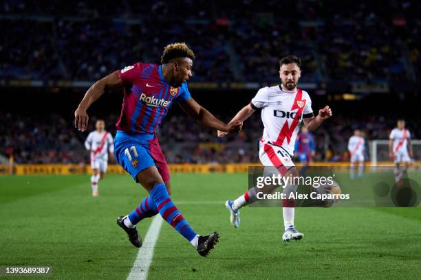 Adama Traore of FC Barcelona plays the ball whilst under pressure from Unai Lopez of Rayo Vallecano during the LaLiga Santander match between FC...