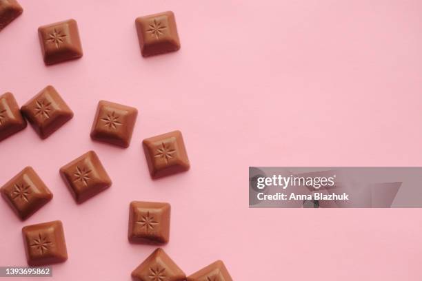 milk chocolate cubes over pink background - candy brown stock pictures, royalty-free photos & images