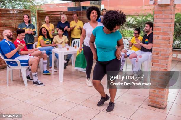 women dancing samba at a barbecue with friends - real people stockfoto's en -beelden