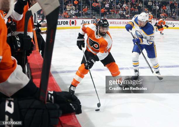 Nate Thompson of the Philadelphia Flyers skates the puck against Casey Mittelstadt of the Buffalo Sabres at the Wells Fargo Center on April 17, 2022...