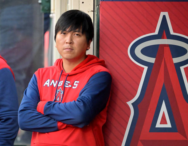 Ippei Mizuhara, translator for Shohei Ohtani of the Los Angeles Angels, stands in the dugout during the game against the Baltimore Orioles at Angel...