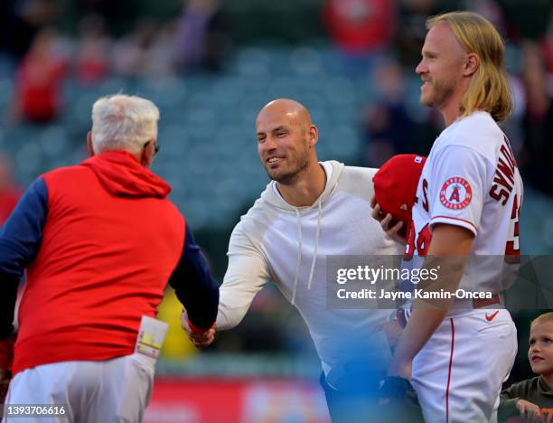 Ryan Getzlaf of the Anaheim Ducks stands next to Noah Syndergaard and he shakes hands with manager Joe Maddon of the Los Angeles Angels before the...