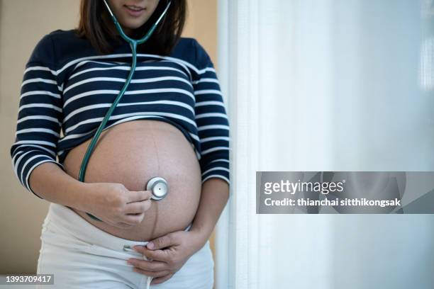 image of hand pregnant woman listen to baby heart beat with doctor stethoscope. - herzton abhören stock-fotos und bilder