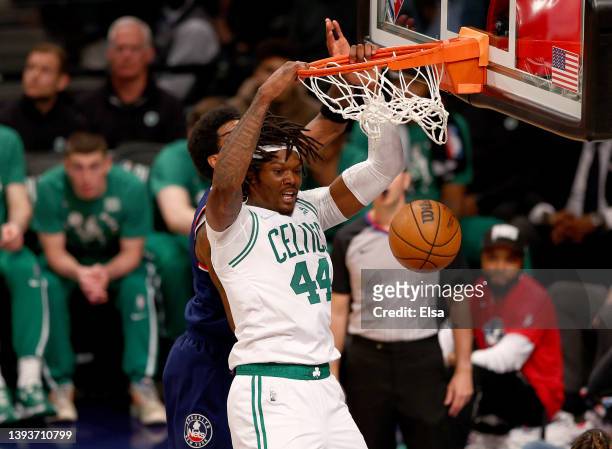 Robert Williams III of the Boston Celtics dunks in the third quarter as Kyrie Irving of the Brooklyn Nets defends during Game Four of the Eastern...