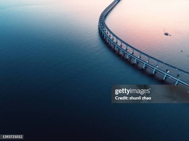 aerial view of cross-sea bridge - curve road stock-fotos und bilder