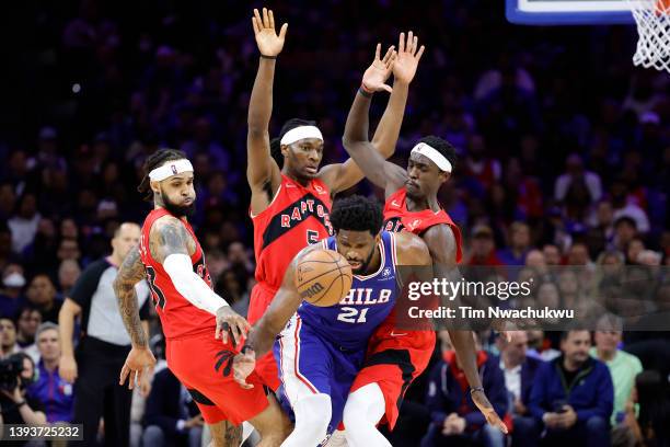 Joel Embiid of the Philadelphia 76ers is guarded by Gary Trent Jr. #33, Precious Achiuwa and Pascal Siakam of the Toronto Raptors in the third...