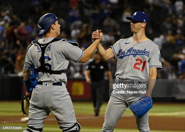 Walker Buehler and Will Smith of the Los Angeles Dodgers celebrate a 4-0 win against the Arizona Diamondbacks at Chase Field on April 25, 2022 in...