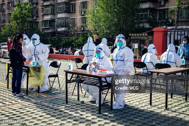 Medical worker collects a swab sample from a resident for COVID-19 nucleic acid test on April 26, 2022 in Beijing, China.