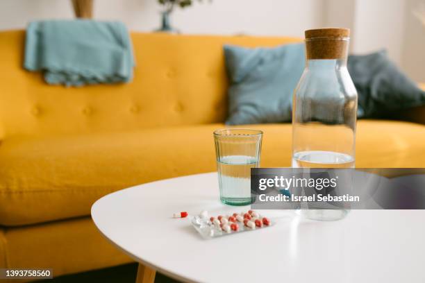 close up view of a table with pills and a glass of water. - prozac stock pictures, royalty-free photos & images